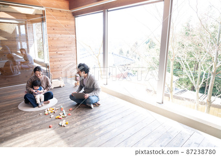 一個漂亮的新木頭大房間，一個快樂的年輕家庭，一個漂亮的媽媽和一個家庭團體。右邊有一個複制空間。 87238780