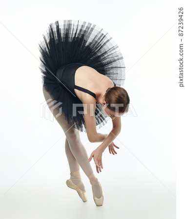 attractive ballerina stands on her fingertips. photo shoot in the studio on a white background attractive ballerina stands on her fingertips. photo shoot in the studio on a white background 87239426
