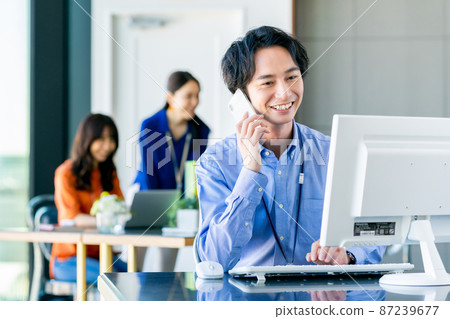 在辦公室打電話的年輕工程師 在辦公室打電話的年輕工程師 87239677