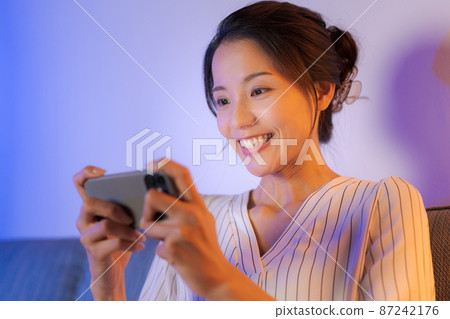 A woman relaxing at home at night 87242176