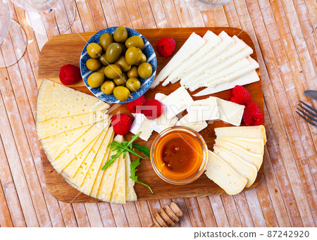 Cheese plate with raspberry and olives 87242920