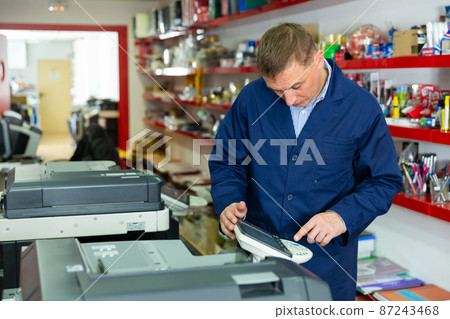 Service engineer using a copy machine 87243468