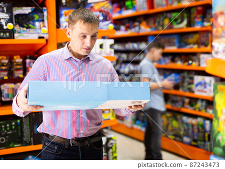 Man shopping in store of kids toys Man shopping in store of kids toys 87243473