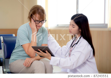 Doctor woman and senior patient explaining and looking on tablet computer for diagnostics. 87243551