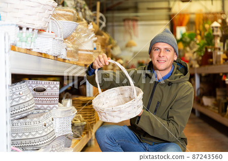Portrait of man searching wicker basket for storage 87243560