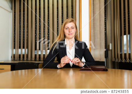 Portrait of successful business woman sitting in her office at negotiating tabl Portrait of successful business woman sitting in her office at negotiating tabl 87243855