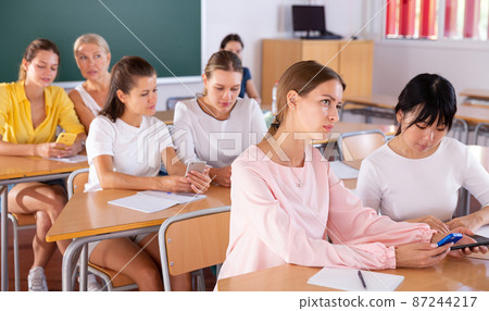 Students working in pairs using phones Students working in pairs using phones 87244217