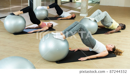 Sporty people training pilates at group class Sporty people training pilates at group class 87244332