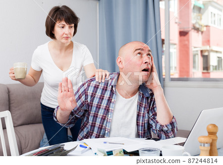Wife calms husband who is upset about financial results. 87244814