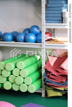 pilates and yoga equipment in a fitness gym. balls, mats and foam rollers on shelfs. stretching and relaxation pilates and yoga equipment in a fitness gym. balls, mats and foam rollers on shelfs. stretching and relaxation 87244881