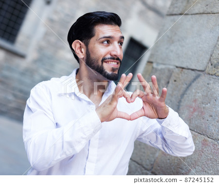 Passionate man making heart with finger 87245152