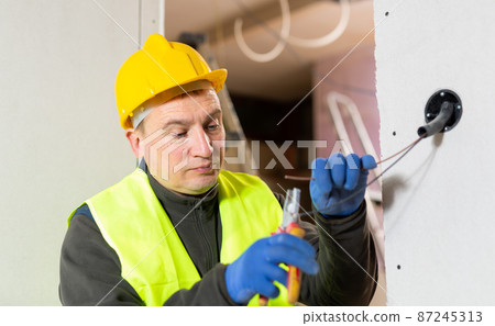 Repair man working on electric wires Repair man working on electric wires 87245313