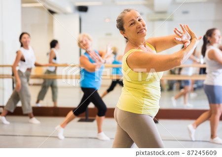 Active women enjoying training in dance studio, dance class for adults Active women enjoying training in dance studio, dance class for adults 87245609