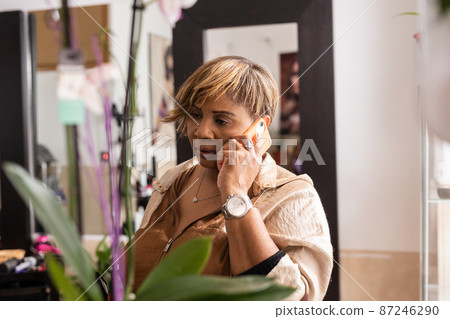 Small business Latin entrepreneur using smartphone technology for her professional beauty salon Small business Latin entrepreneur using smartphone technology for her professional beauty salon 87246290