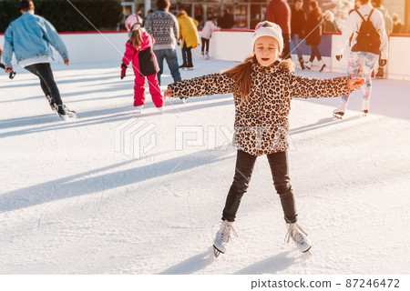 Soft, Selective focus. Group of teenage friends ice skating on an ice rink. Holiday and seasonal concept. Family winter sport. Little adorable girl learning to skate.Activity, Adult, Child, Childhood. Soft, Selective focus. Group of teenage friends ice skating on an ice rink. Holiday and seasonal concept. Family winter sport. Little adorable girl learning to skate.Activity, Adult, Child, Childhood. 87246472