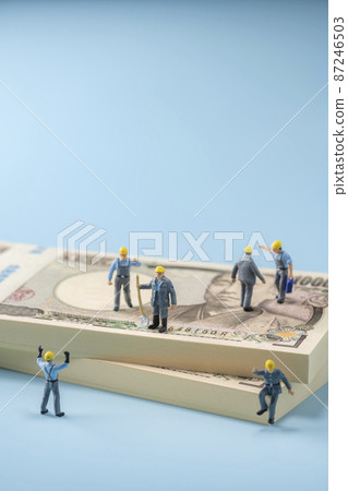 Money (wad of bills) and miniature workers 87246503
