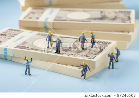 Money (wad of bills) and miniature workers 87246508