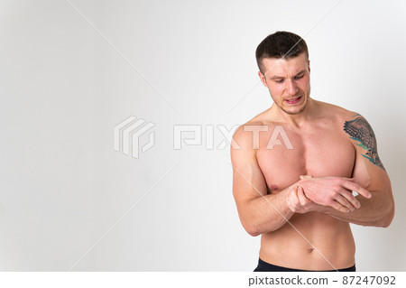 Muscles on the arm ache in a man on a white background ache painful, cramp spine isolated young illness holding. Touching care, back suffer attractive 87247092