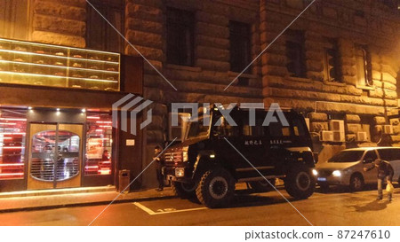 An off-road Mercedes-Benz and a cigarette smoker who parks in front of an old stone building. The figure of a man looking into the back of the car 87247610