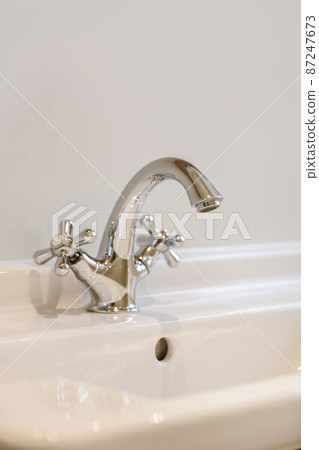 A magnificent comfortable faucet in the sink in an elite bathroom 87247673