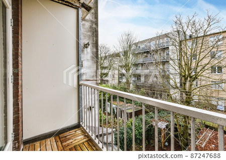 Charming design of a long balcony with iron handrails and a view of a residential building 87247688