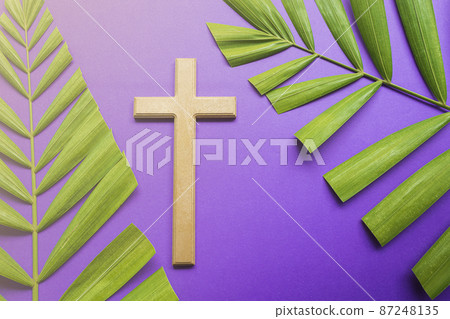 Cross and palm leaves on purple background. Lent season concept. 87248135