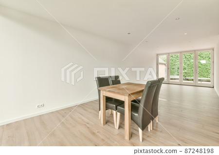 a set of wooden table and black chairs in an empty room a set of wooden table and black chairs in an empty room 87248198