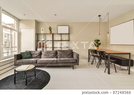 interior of a spacious living room combined with a dining area in a minimalist style 87248568