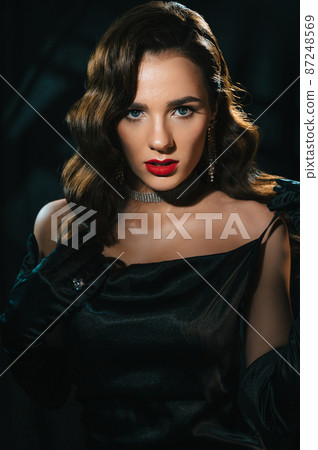 Portrait of a woman in the style of a classic retro Hollywood movie of the 1950s. Elegant young girl with a stylish hairstyle and makeup Portrait of a woman in the style of a classic retro Hollywood movie of the 1950s. Elegant young girl with a stylish hairstyle and makeup 87248569