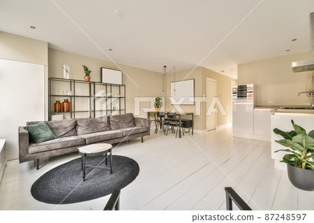 interior of a spacious living room combined with a dining area in a minimalist style interior of a spacious living room combined with a dining area in a minimalist style 87248597
