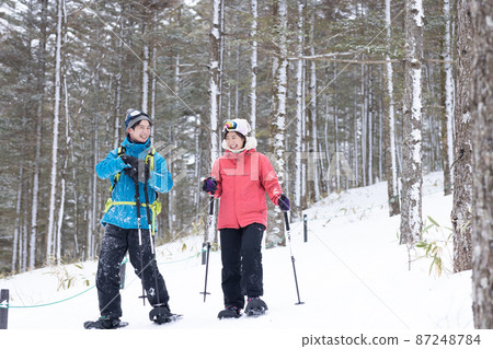 Couple enjoying snowshoes 87248784