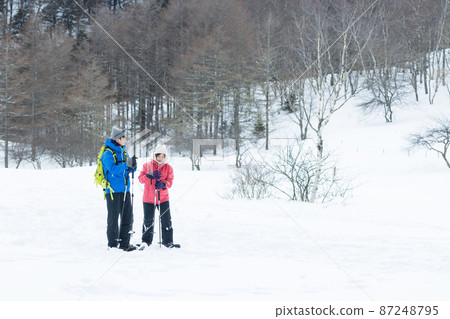 Couple enjoying snowshoes Couple enjoying snowshoes 87248795