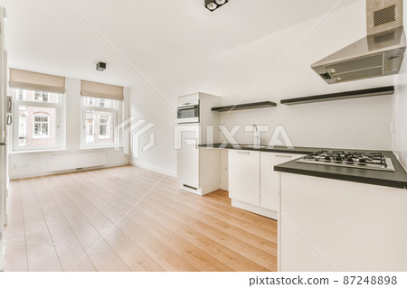 Charming design of a large room with a kitchen area and parquet floor in an elite house 87248898