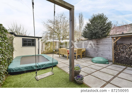 Compact backyard with dining area and play area for kids Compact backyard with dining area and play area for kids 87250095
