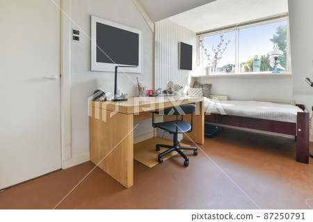 room with a single bed and a working area with a chair 87250791