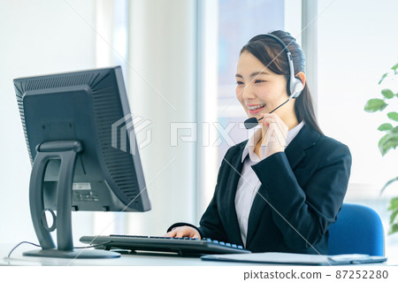 Young female operator chatting with a headset in the office 87252280