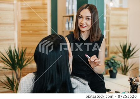 A make-up artist makes makeup for a girl in the salon, applies lipstick, completes the image. The concept of beauty and self-care A make-up artist makes makeup for a girl in the salon, applies lipstick, completes the image. The concept of beauty and self-care 87253526
