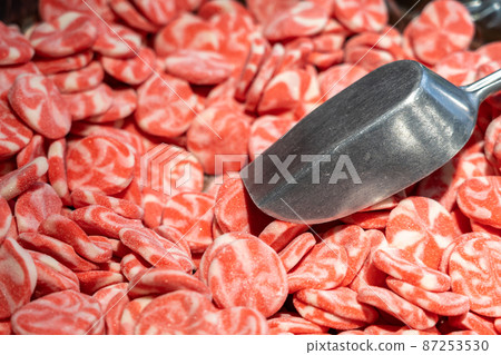 Red sweet candies in a candy store with metal scoop Red sweet candies in a candy store with metal scoop 87253530