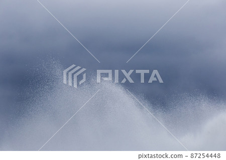 Splashes of water fountain movement of liquid flow against the dark blue sky background 87254448