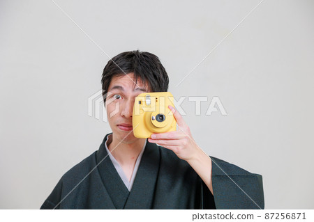 Japanese man in kimono with a film camera 87256871