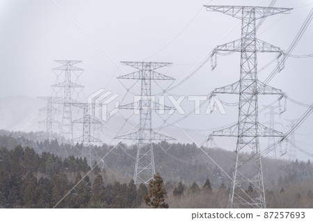 Towers and power lines in the snow 87257693