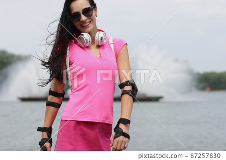 Stylish sportswoman in pink sportswear outdoors Stylish sportswoman in pink sportswear outdoors 87257830