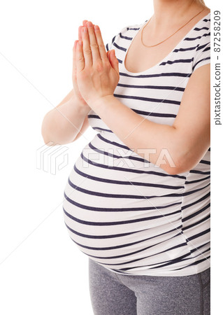 Pregnant woman doing yoga asana asana Tadasana namaste -Mountain pose with salutation Pregnant woman doing yoga asana asana Tadasana namaste -Mountain pose with salutation 87258209