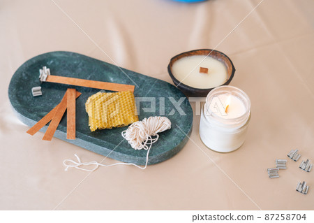 Close-up view of components for production of aromatic eco handmade candles on light background. Closeup composition with ingredients for scented home-made candles. Close-up view of components for production of aromatic eco handmade candles on light background. Closeup composition with ingredients for scented home-made candles. 87258704