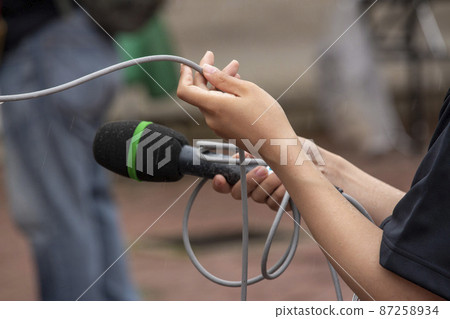 A woman interviewing with a microphone A woman interviewing with a microphone 87258934