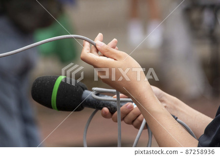 A woman working with a microphone in one hand A woman working with a microphone in one hand 87258936