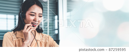 Businesswoman wearing headset working actively in office 87259595