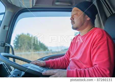 Male driver dozing while driving a heavy truck Male driver dozing while driving a heavy truck 87260131