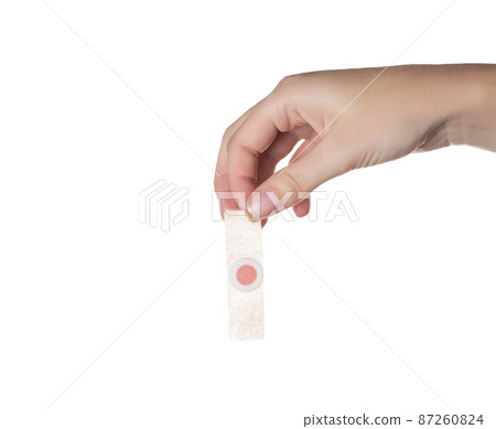 The girl holds in her hand a medical plaster against core calluses on the soles of the feet. White background, isolate The girl holds in her hand a medical plaster against core calluses on the soles of the feet. White background, isolate 87260824