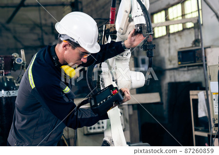 Young factory worker working with adept robotic arm Young factory worker working with adept robotic arm 87260859